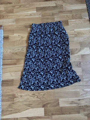 Blommig långkjol  - Säljer en svart långkjol från 157 med vitt blommönster, har slits i båda sidorna där nere. Storlek S💞