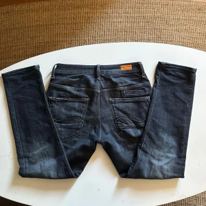 Mörkblå Jack&Jones jeans - Säljer ett par snygga mörkblåa Jack&Jones jeans med snygg tvätt i passformen Tapered Mike,,,,,,,,,,,  Storlek 28/30, Modellen är ca 175cm lång