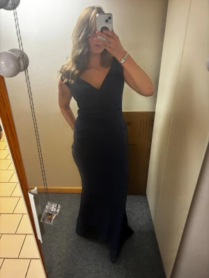 Marinblå långklänning från Goddiva  - Elegant marinblå långklänning med v-ringad hals och figurnära passform. Klänningen har breda axelband och en stilren, enkel design med lite ”scrunch”. Den har en dragkedja vid sidan. Ganska liten i storleken (jag brukar ha 38 i tröjor och 38/40 i byxor). Tänkte ha denna på min studentbal men hittade en annan jag ville ha. Den är helt ny (endast provad) och har prislappen kvar💗 Nypris 999kr! Bara skriv om du vill ha fler bilder eller har några frågor😚 Pris kan diskuteras vid smidig affär!