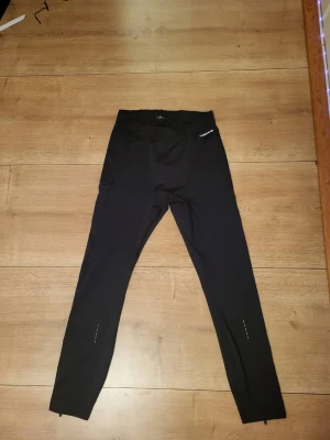 Svarta träningsleggings från Yosemite - Säljer ett par svarta träningsleggings från Yosemite med smal passform och reflexdetaljer vid benen. Perfekta för löpning eller gymmet. Elastisk midja och stretchigt material för maximal rörelsefrihet.