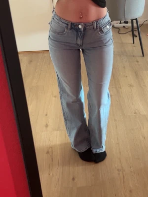 Ljusblå jeans med ficklock - Säljer ett par ljusblå jeans med en medel midja och ficklock bak. Jeansen har klassisk femficksdesign och raka ben. Perfekta för en avslappnad look. knappt använda. Hör av dig vid fler bilder eller frågor ❤️