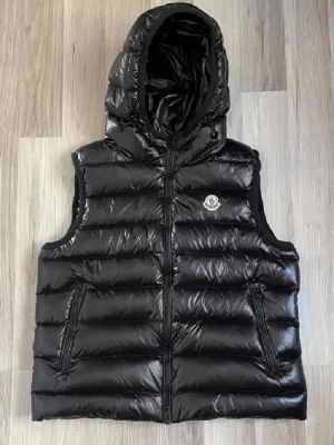  Moncler väst - Säljer nu min moncler väst i size 3 skulle säga att det motsvarar strl M. Den är svart glansig med luva, två ytterfickor och en innerficka. Den är unisex så passar både tjejer och killar.