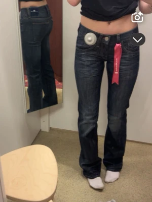Skit snygga boot cut jeans!!😍 - Säljer dessa skit snygga jeansen!! De är mörkblå/grå ish färgade med vissa sömmar röda vilket gör dom väldigt unika och snygga😍😍 De är bootcut och low waisted med väldigt snygg passform! Pris kan diskuteras vid snabb affär💕
