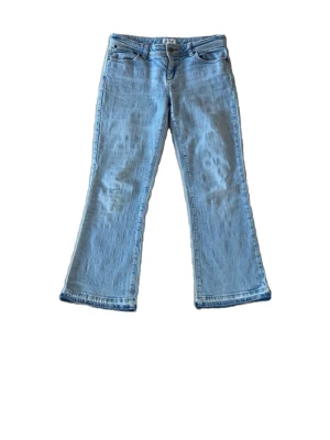 Super lågmidjade vintage  jeans - Säljer ett par ljusblå bootcut jeans med klassisk femficksdesign och låg midja. Jeansen har utsvängda ben och är tillverkade i mjuk denim. Perfekta för dig som gillar retrovibbar och en avslappnad stil. Dem är i en ”petite” model och är en aning mindre än en vanlig 36:a😊