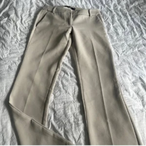 Beige kostymbyxor med pressveck - Lågmidjaze kostymbyxor från bikbok 