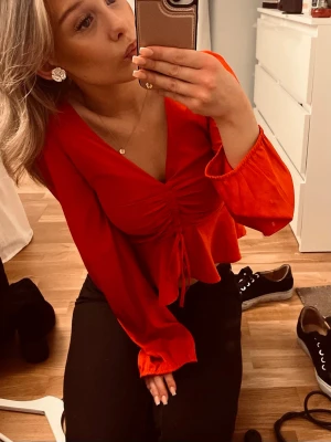 Röd långärmad blus med rynk framtill - Snygg röd blus från bikbok, har ett hål vid drakedjan, se bild 4