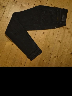 Två par jeans i svart och blå denim - Säljer två par jeans, ett par svarta med rak passform och ett par blå skinny jeans. Båda har klassisk femficksdesign och är tillverkade i denim. Perfekta för dig som gillar enkel och stilren look.