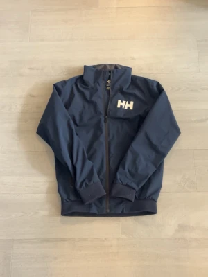 Helly Hansen Windbreaker - Riktigt fet mörkblå windbreaker från Helly Hansen i storlek S, använd men i riktigt fint skick. Perfekt nu till våren!🙌 Mer frågor privat💯