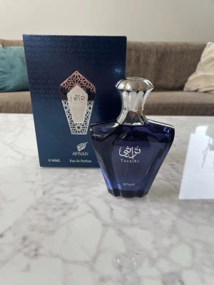 Afnan Turathi Eau de Parfum 90ml - Afnan Turathi Eau de Parfum i en elegant mörkblå glasflaska med silverfärgat lock. Flaskan har en unik, lyxig form och levereras i en snygg presentförpackning. Doften är orientalisk och exklusiv, perfekt för dig som vill sticka ut. Bra skick, inte använt så mycket. ( 90 ml )