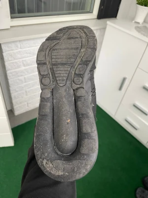 Nike Air Max svart sneaker - Säljer ett par svarta Nike Air Max sneakers med klassisk chunky sula och diskret Nike-logga. Skorna har en sportig look och är tillverkade i textil och syntetmaterial. Perfekta för dig som gillar streetwear och vill ha bekväma skor till vardags.