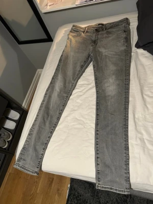 Grå slim fit jeans från uniqlo - Säljer ett par grå slim fit jeans från uniqlo. Jeansen har klassisk femficksdesign, normal midja och smal passform. Materialet är mjukt och stretchigt för extra komfort. Perfekta för en avslappnad men ändå snygg look.