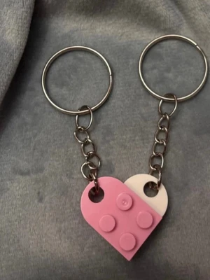 Nyckelring legobitar hjärta nyckelringar för par  - Ett gulligt par nyckelringar med var sin legobit som tillsammans bildar ett hjärta! Fint att dela med sin bästis, partner eller någon annan som betyder mycket. Varje legobit är ca 2 x 1,5 cm och hela nyckelringen är ca 6,5 cm lång.