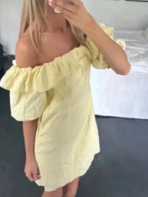 Gul offshoulder klänning med volang - Söt kort gul klänning med offshoulder och volangdetaljer runt halsen. Klänningen har puffiga korta ärmar och en feminin, luftig form. Perfekt för sommarens alla fester.❤️