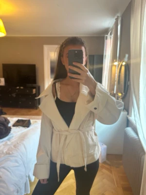 Vit jeansjacka med bälte - Snygg vit jeansjacka med bred krage och knytbälte i midjan. Den går att ha på flera olika sätt och är helt ny🌟🌟skriv vid frågor eller prisförslag!!💕💕