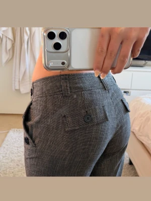 vintage kostymbyxor med knappar - Vintage kostymbyxor från lindex. De har ett fint unikt mönster med detaljer som knappar fram och bak. Dem är låg/mid waist på mig. Brukar har 36 men dessa har passat i 38 för den oversized looken.