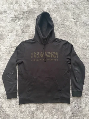 Svart Hugo Boss hoodie - Svart Hugo Boss hoodie i storlek L. Använd men i bra skick, skriv vid frågor!
