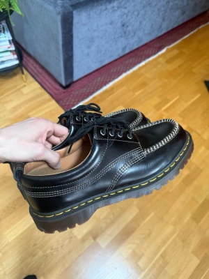 Svarta loafers med grov sula - Säljer ett par svarta dojor i läder av doc Marten med kraftig, räfflad sula och gul söm runt sulkanten. Använd 1 gång men lite stora på mig 