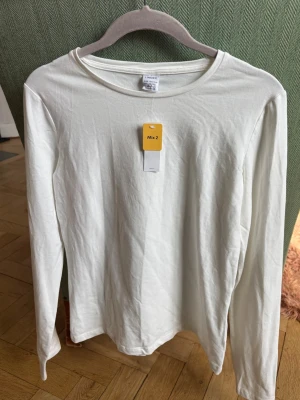 Vit långärmad T-shirt från Lindex - Vit långärmad T-shirt från Lindex. Storlek 158/164. Aldrig använd med etikett kvar. 