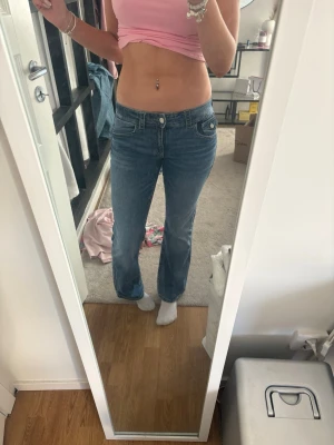 Low waist Gina tricot jeans - Säljer ett par klassiska blå bootcut jeans med låg midja och snygg fickdetalj bak med knapp.💗 Säljer pågrund av att dem är för korta för mig! Andvända typ 5 ggr💕