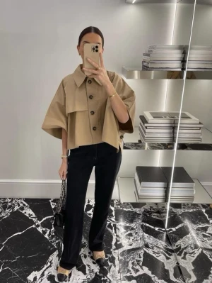 trench coat - Trendig beige overshirt med stora knappar och krage. Jackan har en croppad passform och vida, korta ärmar. Perfekt för lager-på-lager och en stilren look.