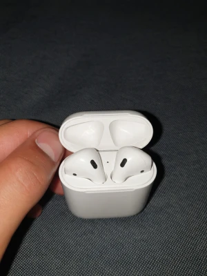 Apple AirPods (Gen 1) – Äkta & Felfritt batteri - Säljer ett par vita Apple AirPods med tillhörande laddningsetui. Trådlösa in-ear hörlurar i stilren design med slät yta och smidigt fodral. Perfekta för musik, samtal och poddar. Kopplas enkelt till din iPhone eller annan enhet via Bluetooth.