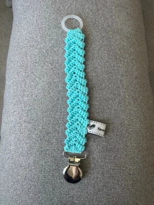 Virkad napphållare - Virkad, turkosblå napphållare, virkad av mig i 100% bomullsgarn med metallclips och silikonring.  Mönsterskapare: animo.design