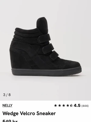 Svarta wedge sneakers med kardborre - Snygga svarta sneakers från Nelly med kilklack och tre breda kardborreband. Skorna har en hög siluett och är tillverkade i mockaliknande material med gummisula. Perfekta för dig som vill ha både stil och höjd i vardagen. Använt ett par gånger bara