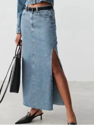 Lång jeanskjol med slits - Trendig lång jeanskjol i ljusblå denim med hög midja och en snygg slits på sidan. Kjolen har klassiska fickor och bälteshällor, perfekt för en avslappnad men stilsäker look. Passar till både sneakers och klackar.