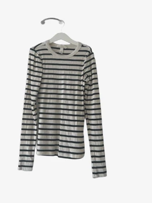 Randig långärmad topp i bomull🌸 - Snygg långärmad topp med svarta och vita ränder. Tillverkad i mjuk bomull med rund halsringning och normal passform. Perfekt att styla med jeans eller kjol för en enkel och trendig look.
