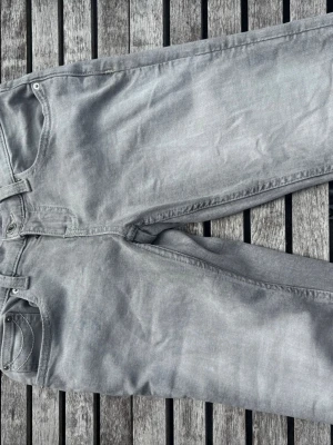 Grå raka jeans från Ginatricot - Säljer ett par grå jeans från Gina med klassisk femficksmodell och raka ben. Jeansen har bälteshällor, knappgylf och är tillverkade i ett mjukt denimtyg. Mycket snygga och passar perfekt för både vardagen och för att klä upp sig!🙂