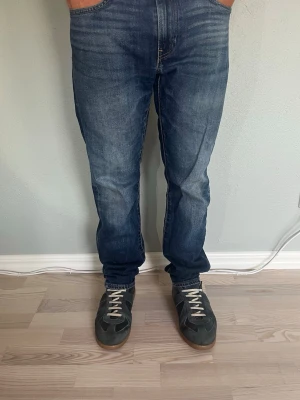 Levi's Premium 502 W31 L32 – Tapered fit | Mörkblå vintage wash - LEVI’S PREMIUM 502  Storlek: W31 L32 Passform: Tapered (smalnar av nedåt) Färg: Mörkblå med naturlig fading Lot: 502 Linje: Levi’s Premium — San Francisco, Cal.  Levi’s Premium-linje är ett snäpp upp i kvalitet jämfört med standardmodellerna — tjockare denim och finare detaljer  Fin naturlig fading vid låren och en mörk, mångsidig tvätt  Modellen på bilden är 175cm och väger 65kg.  Skick: Mycket bra skick men lagade i skrevet men syns inte vid användning. Nypris: ca 1 400 SEK 