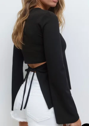 Svart långärmad topp med knyt - Trendig svart långärmad topp med öppen rygg och knyt i midjan. Det går att för fler bilder på plagget vid intresse. 