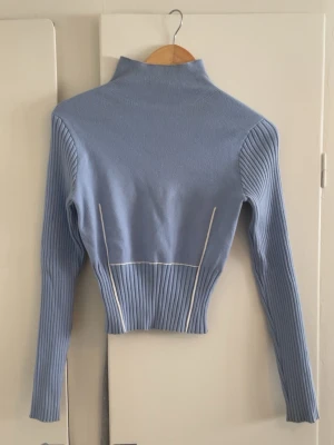 Ljusblå stickad tröja - Ljusblå tröja med hög hals från NAKD. Säljer den för 150kr 🥰