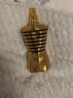 Jean Paul Gaultier Le Male Gold EdT - Unik parfymflaska i form av en manlig torso från Jean Paul Gaultier. Flaskan är helguldig med horisontella ränder och har en metallisk finish. Perfekt för dig som vill ha en ikonisk och lyxig doft på hyllan.