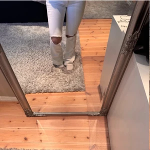 Vita flare jeans med hål på knäna💓 - (Lånade bilder från förra säljaren) Säljer ett par vita utsvängda jeans med slitningar på båda knäna. Jeansen har hög midja och klassisk femficksmodell. Perfekta för en trendig och avslappnad stil. Säljer då de är för små. 