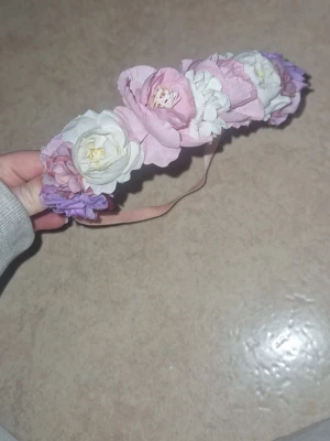 Mjuk diadem - Säljer ett diadem dekorerat med stora konstgjorda blommor i pastellrosa, vitt och lila. Diademet har ett mjukt, ljusrosa band.  Perfekt för att ge en romantisk och bohemisk touch till din look. Inga defekter 
