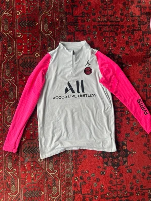 PSG träningströja vit/rosa Jordan - Säljer en snygg PSG träningströja från Jordan i vitt med rosa ärmar. Slim fit. 