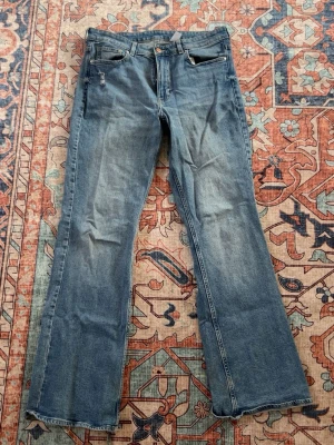 Blå bootcut jeans  - Ett par blå bootcut jeans. Köpt 2 år sen. Highwaist. I botten finns de lite slitning pga regn men kan enkelt klippas bort. 