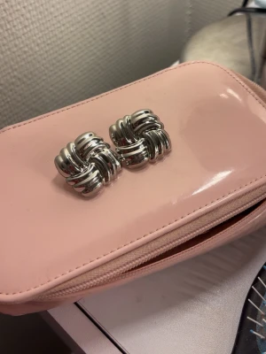 Ani-inspirerade silverörhängen – statement - Säljer örhängen i rostfritt stål från Olympia, helt nya och aldrig använda.  De är en kopia av de populära Ani-örhängena och har varit ganska trendiga. Väldigt coola och stiliga, perfekta om du vill ha något som sticker ut utan att vara överdrivet.  Nypris: 129 SEK