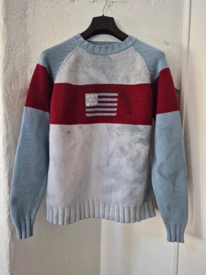 Vintage 90-00tal stickad bomull tröja blå röd - Riktigt snygg grovstickad vintagetröja från River Woods, sent 90-tal/00-tal 100% bomull, syratvättad, ljusblå/röd Muddar vid hals, ärmslut och nedtill Står som storlek L men skulle säga dagens M/L Ärmhåla till ärmhåla ca 60 cm, längd ca 70 cm I kanonskick 