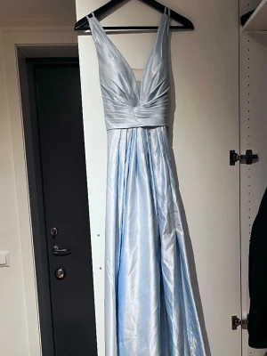 Ljusblå långklänning med v-ringning - Ljusblå balklänning från jjs house använd 1 gång i fint skick. Passade bra på mig som är 166cm lång med ett par 10cm klackar skulle säga att det är storlek 36. Priset är inte fast kom med bud!😊