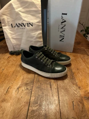 Olivgröna Lanvin I 42,5 - Snygga olivgröna lanvins med vit sula. Skicket är generellt sett bra, mockan är i använd men bra skick, samma sak med sulan. Storleken är 8 eller ungefär 42,5. Tygpåse och extra snören ingår men inte box, extrasnörena är inte i nytt skick. Tån är matt och har bortflagnad färg på lacken, se bild. Jag säljer de pågrund av att de är för små! Hör av dig vid prisförslag eller andra frågor! 