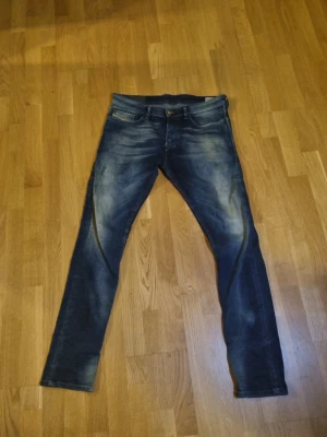 Disel jeans unika  - Säljer ett par blå slim fit jeans från disel med snygga slitningar och tvättade detaljer. Klassisk femficksmodell med knappgylf och bälteshällor. Jeansen har en modern passform och är perfekta till en avslappnad stil. Slimfit. Storlek 31/32 sitter bra
