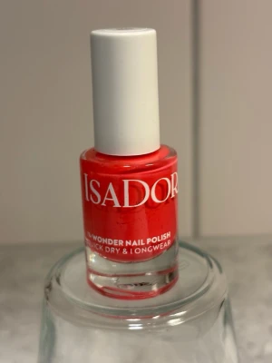 Isadora Wonder Nail Coral Flare - Snyggt nagellack från Isadora i färgen Coral Flare, en livlig korallnyans som verkligen poppar. Kommer i en klassisk glasflaska med vitt lock och rymmer 5 ml. Lacket är snabbtorkande och har lång hållbarhet, perfekt för dig som vill ha färgstarka naglar. Använd enbart en gång! 