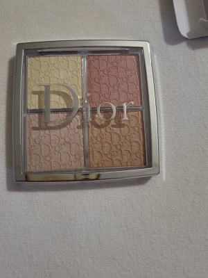 Dior Backstage Glow Face Palette - Dior Backstage Glow Face Palette är en highlighterpalett med fyra nyanser: Sheer Gold Pearl, Shimmer Rose, Metallic Pink Gold och Metallic Golden Peach. Paletten har en spegelblank silverförpackning och ger ett skimrande, blendbart resultat för ansiktet.