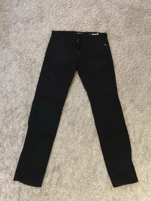 Svarta jeans Replay Anbass - Säljer ett par svarta jeans från Replay, modell Anbass. Klassisk femficksdesign med smal passform och dragkedjegylf. Snygga och stilrena jeans som passar till det mesta. Materialet är mjukt och stretchigt för extra komfort.