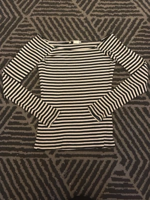 Svartvit randig långärmad topp - Snygg långärmad topp med svarta och vita ränder från HM. Modellen är figurnära med bred, något båtformad halsringning. Tillverkad i ett stretchigt ribbat material som sitter skönt på kroppen. Perfekt att matcha med jeans eller kjol. Knappt använd så väldigt bra skick, säljer då den inte kommer till användning och för liten. Tveka inte på att höra av dig för fler frågor eller bilder🤗