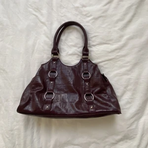 Vintage lila handväska - Super snygg Vintage lila hadväska, i fantastiskt skick! Väskan är perfekt storlek för vardagen. Det enda är att jag råkade tappa all min blush i väskan så den är✨✨✨ Annars är det inga konstigheter!! Kontakta mig vid frågor eller intresse!