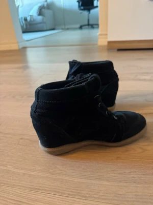 Svarta kilklackade boots i mocka - Pavement - Säljer ett par svarta boots med kilklack och snörning från Pavement! Perfekta för dig som vill ha lite extra höjd men ändå vara bekväm. Använd några gånger men säljer då de är lite stora. Tveka inte på att höra av dig vid frågor💞