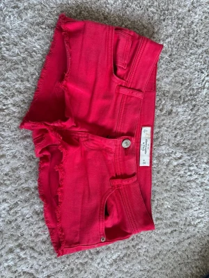 Röda jeans shorts  - Snygga röda low waist shorts från Abercrombie & Fitch i strl 25, skulle säga att det är en xs eller s❤️ 